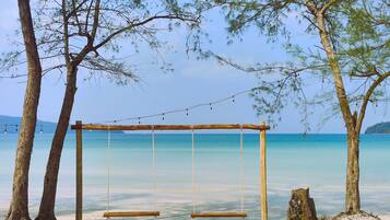 Na praia, areia branca, espreguiçadeiras