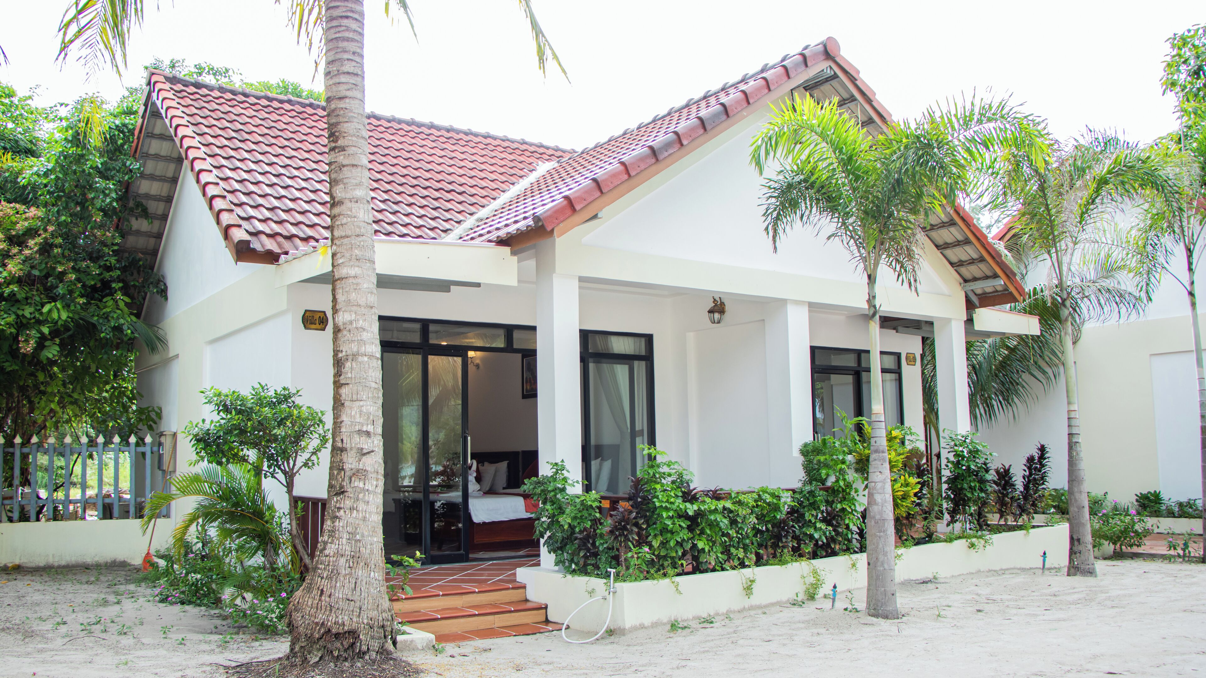 A two-story building with a tiled roof, large windows, and a covered entrance.
