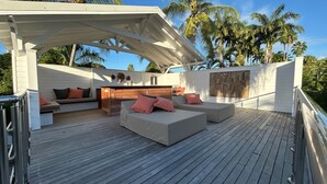 A wooden deck with outdoor seating and a covered area.