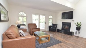 A living room with a brown leather sofa, a wooden coffee table, and a fireplace.