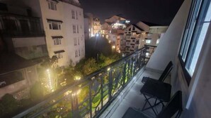 Un balcón con vistas a edificios cercanos por la noche.