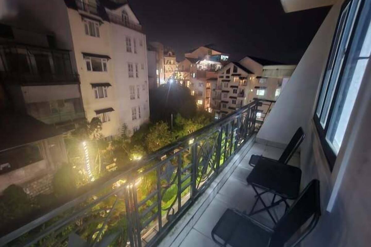 Un balcón con vistas a edificios cercanos por la noche.