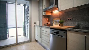 A modern kitchen with a stainless steel dishwasher, a built-in oven, and a granite countertop. - Apartment FALCÓN by HR COSTABRAVA (Castell-Platja d'Aro)