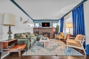 A living room with a fireplace, a television, and a sofa. - Hot Tub - Game Room - FirePit - Minutes to Downtown Cleveland (Cleveland)