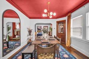 A dining area with a red ceiling, a chandelier, and a table set for four. - Hot Tub - Game Room - FirePit - Minutes to Downtown Cleveland (Cleveland)