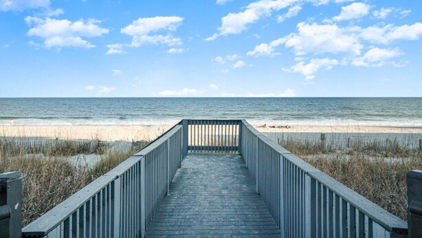 A wooden boardwalk leading to a beach with a clear sky and ocean view. - Oceanfront 2bd/2ba Amazing Views, Myrtle Beach (Myrtle Beach)