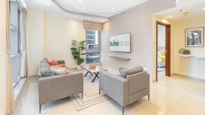 Un salon moderne avec un canapé, des fauteuils, une table basse et une plante en pot.
