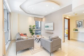 Una sala de estar moderna con un sofá, sillones, una mesa de centro y una planta en maceta.