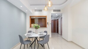 Un espace repas moderne avec une table ronde, quatre chaises et un vase de fleurs.