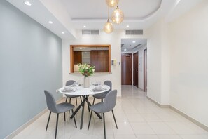 A modern dining area with a round table, four chairs, and a vase of flowers. - Sophisticated and Elegant 2BR in Downntown Dubai (Dubai)