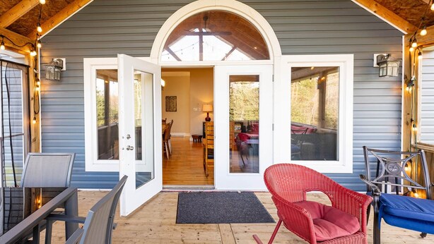 Un portico coperto con soffitto in legno e un'ampia porta ad arco che dà su un ambiente interno.