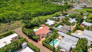 A residential area with houses, a swimming pool, and lush greenery. - Casa linda Villa 918 (Sosúa)