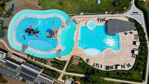 An aerial view of a resort with multiple swimming pools, a beach area, and a parking lot. - Casa linda Villa 918 (Sosúa)