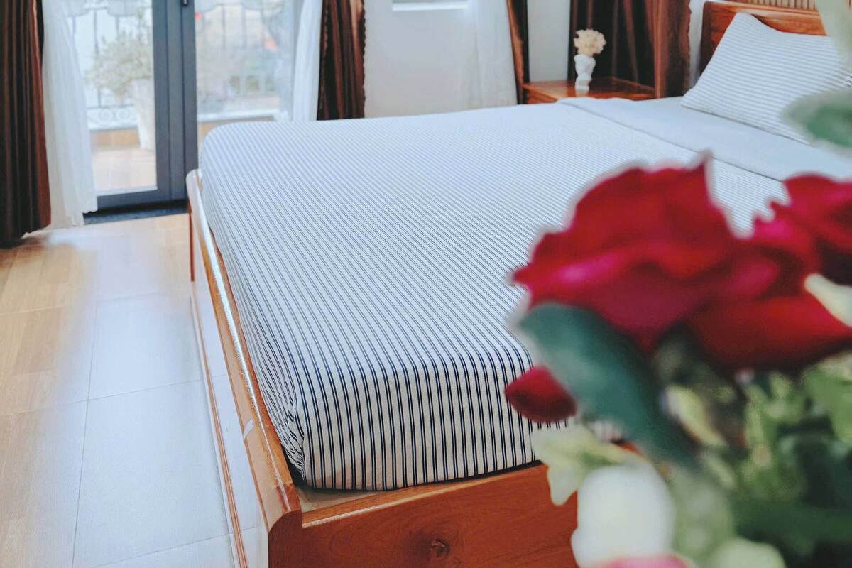Une chambre à coucher avec un lit, des rideaux et une vue sur l’extérieur.