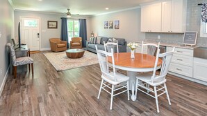 Una sala de estar amplia con comedor, cocina y baño.