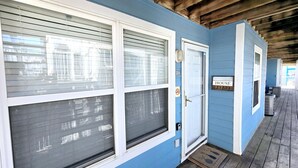 A blue house with a '204' number, a 'Beach House' sign, and a covered porch with a doormat. - Sunchase 204 | Pool & Hot Tub | Steps to the Beach (Gulf Shores)