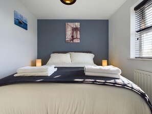 Cozy retreat with a large bed, bedside tables, and a window with blinds.