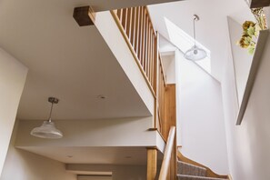 A staircase with wooden railings and a white wall.