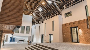A spacious interior with high ceilings, exposed wooden beams, and large windows. - Frieda - Modern Vacation Rental in Rysum near Greetsiel, 92 m²/6 people - Hof Van (Rysum)