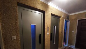 A hallway with three doors, each with a small window and a light above the door. - Lisbon spacious T2 in Damaia, Lisbon (Amadora)