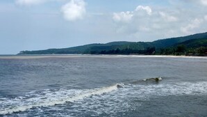 A coastal landscape with a beach and hills in the background. - Shobha Farmhouse (Murud)
