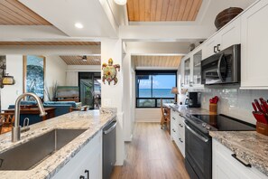 Una cocina moderna con encimeras de granito, horno empotrado y vistas al exterior.