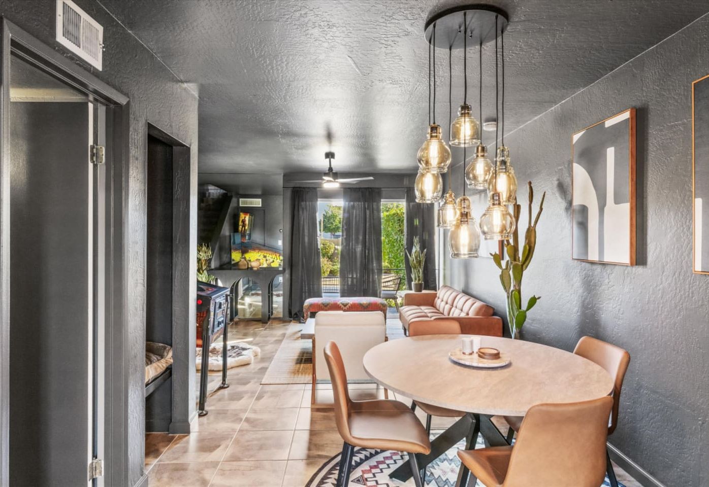 Un espace repas comprenant une table ronde, des chaises et des luminaires suspendus.