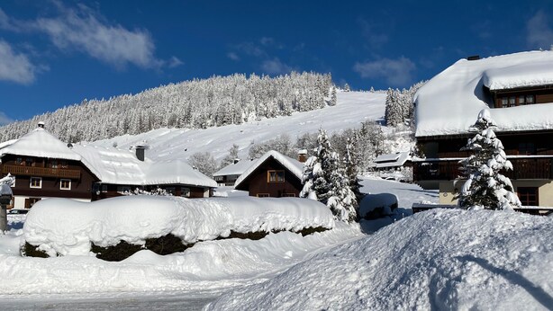 A snow-covered village with wooden houses, a ski slope, and a clear blue sky. - Apartment 'Am Blaubeerhang' with Mountain View, Private Terrace and Wi-Fi (Sankt Blasien)