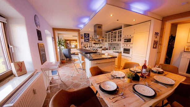 A modern kitchen with white cabinets, a dining table set for four, and a visible clock on the wall. - Apartment 'Gemütliche Wohnung' with Mountain View, Shared Terrace and Wi-Fi (Anger)