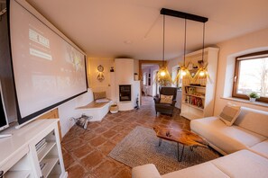 A living room with a white sofa, a wooden coffee table, a TV, and a bookshelf. - Apartment 'Gemütliche Wohnung' with Mountain View, Shared Terrace and Wi-Fi (Anger)