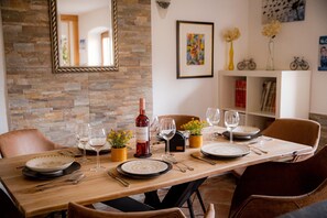 A dining table set with plates, cutlery, wine glasses, and a bottle of wine. - Apartment 'Gemütliche Wohnung' with Mountain View, Shared Terrace and Wi-Fi (Anger)