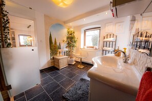 A bathroom with a bathtub, a sink, a window, and a mirror. - Apartment 'Gemütliche Wohnung' with Mountain View, Shared Terrace and Wi-Fi (Anger)