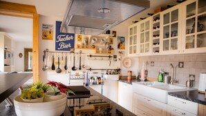 A kitchen with white cabinets, a black countertop, and a sign that reads 'Tucher Bier.' - Apartment 'Gemütliche Wohnung' with Mountain View, Shared Terrace and Wi-Fi (Anger)