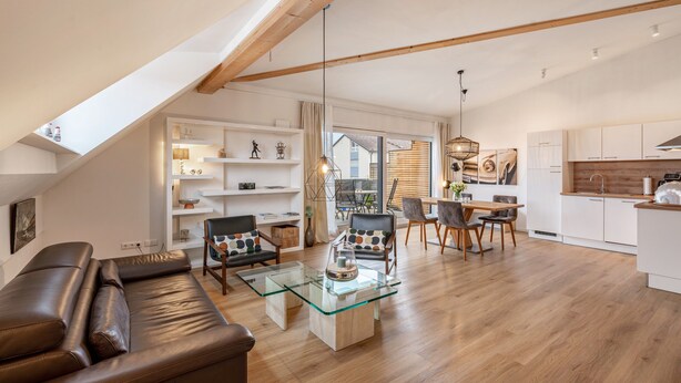 Un appartement moderne de style « loft » comprenant un coin repas, une cuisine et un espace de vie.