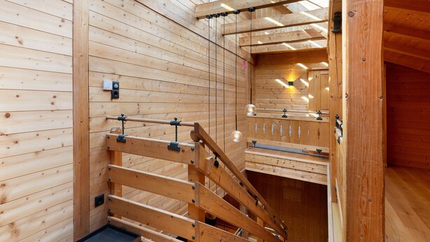 A wooden interior with a wooden staircase, a small table, and a wall-mounted light fixture. - Holiday Appartment "Steinbock" in Sankt Anton am Arlberg with Mountain View, Balcony and Wi-Fi (Sankt Anton am Arlberg)