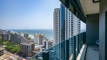 A high-rise building with a view of the ocean and other buildings.