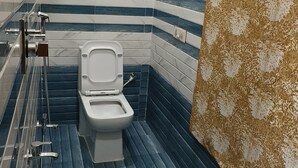 Une salle de bain avec des toilettes, une douche et un rideau à motifs.