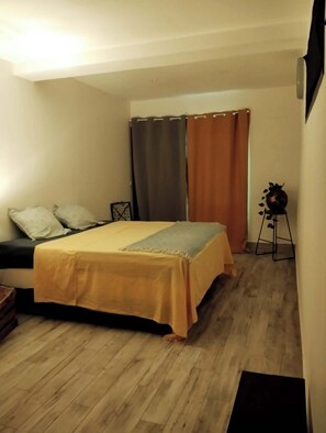 A bedroom with a bed, a nightstand, a lamp, and a window with curtains. - ROOM 1 - ROOM in apartment, 2 min. walk from ferry dock (Papeete)