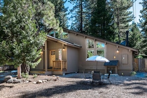 A cabin with a porch, a covered seating area, and a gravel driveway. - Majestic Pines Tahoe City (Tahoe City)