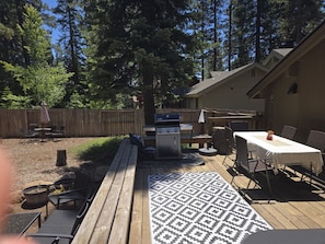 A backyard with a barbecue grill, outdoor seating, and a covered table. - Majestic Pines Tahoe City (Tahoe City)