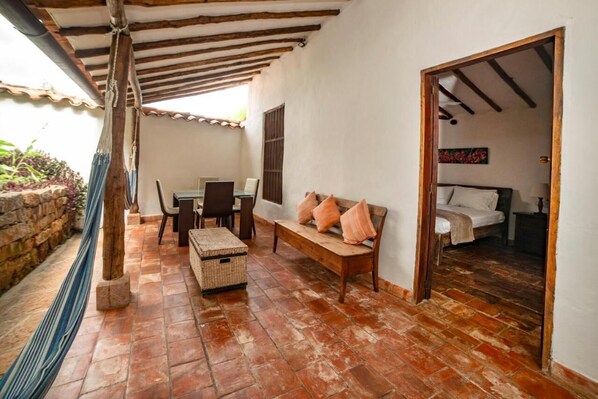 A cozy room with a wooden bench, a small table, and a bed.