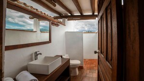 A bathroom with a white sink, a mirror, and a toilet. - Spacious Family Room – Achiotte, Colombia (Barichara)