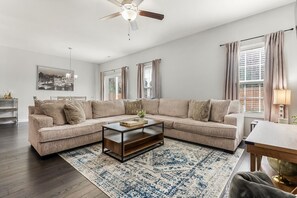 Relax in this inviting living space with a large L-shaped sofa, coffee table, and patterned rug.