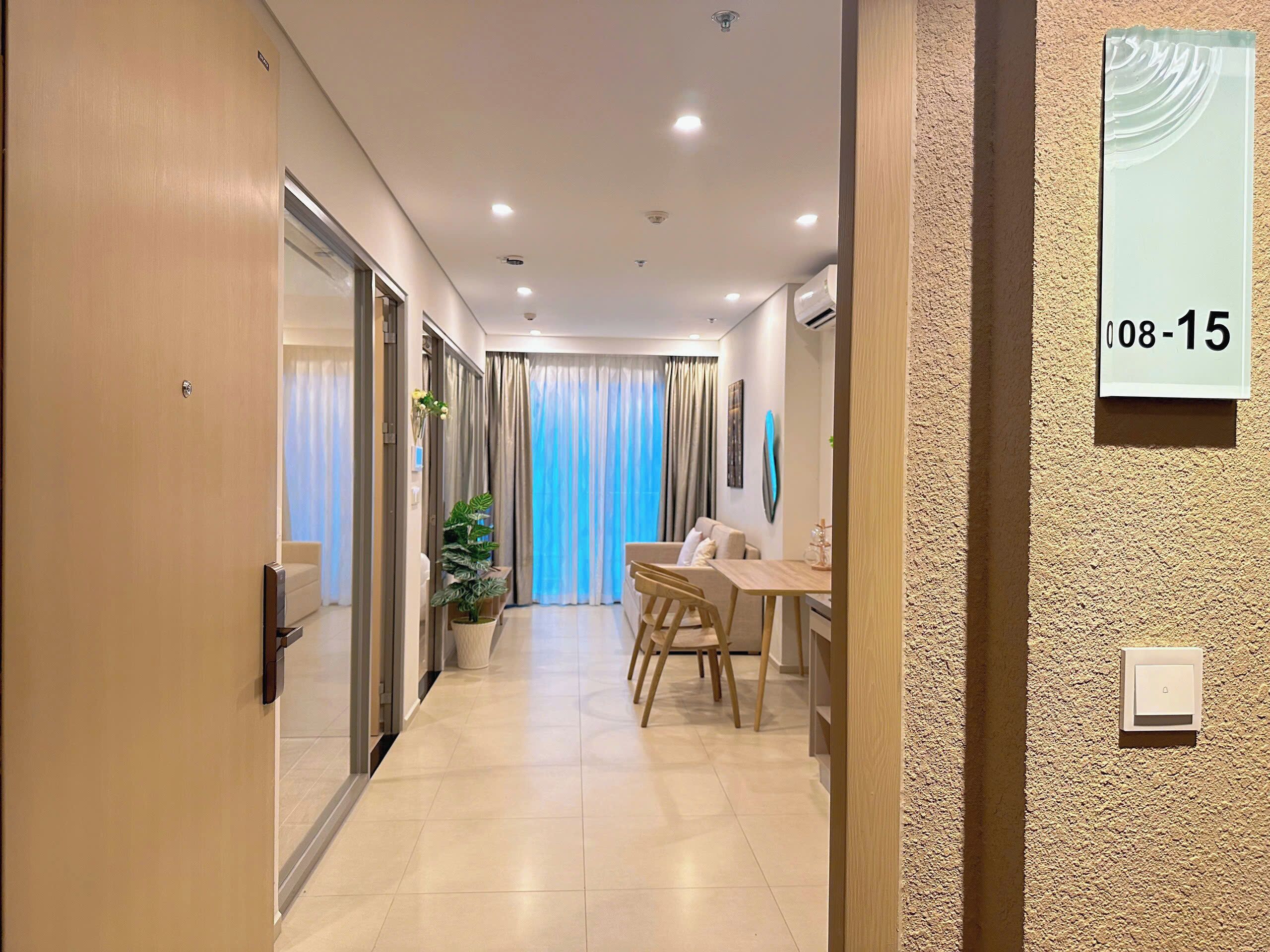 Un couloir d’hôtel avec un comptoir d’accueil, un espace repas et une grande fenêtre avec des rideaux.