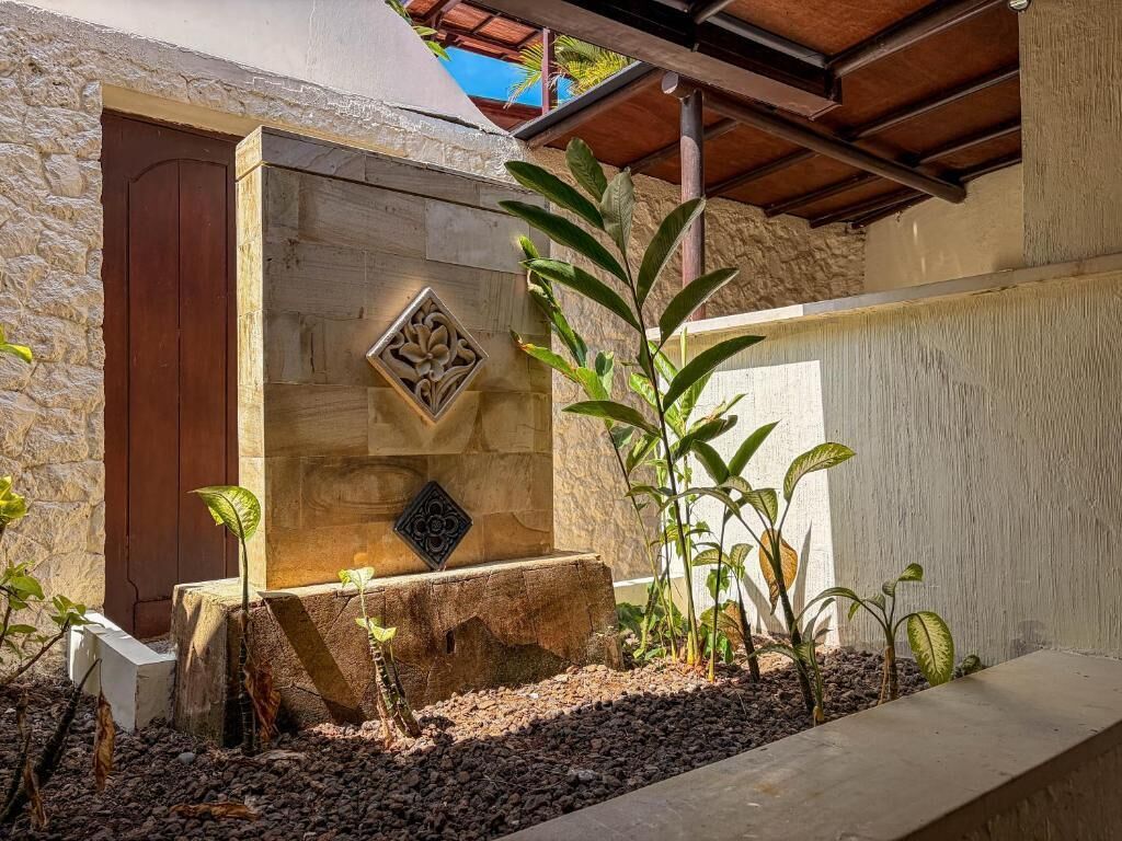 Un muro de piedra con una puerta de madera y un adorno metálico.