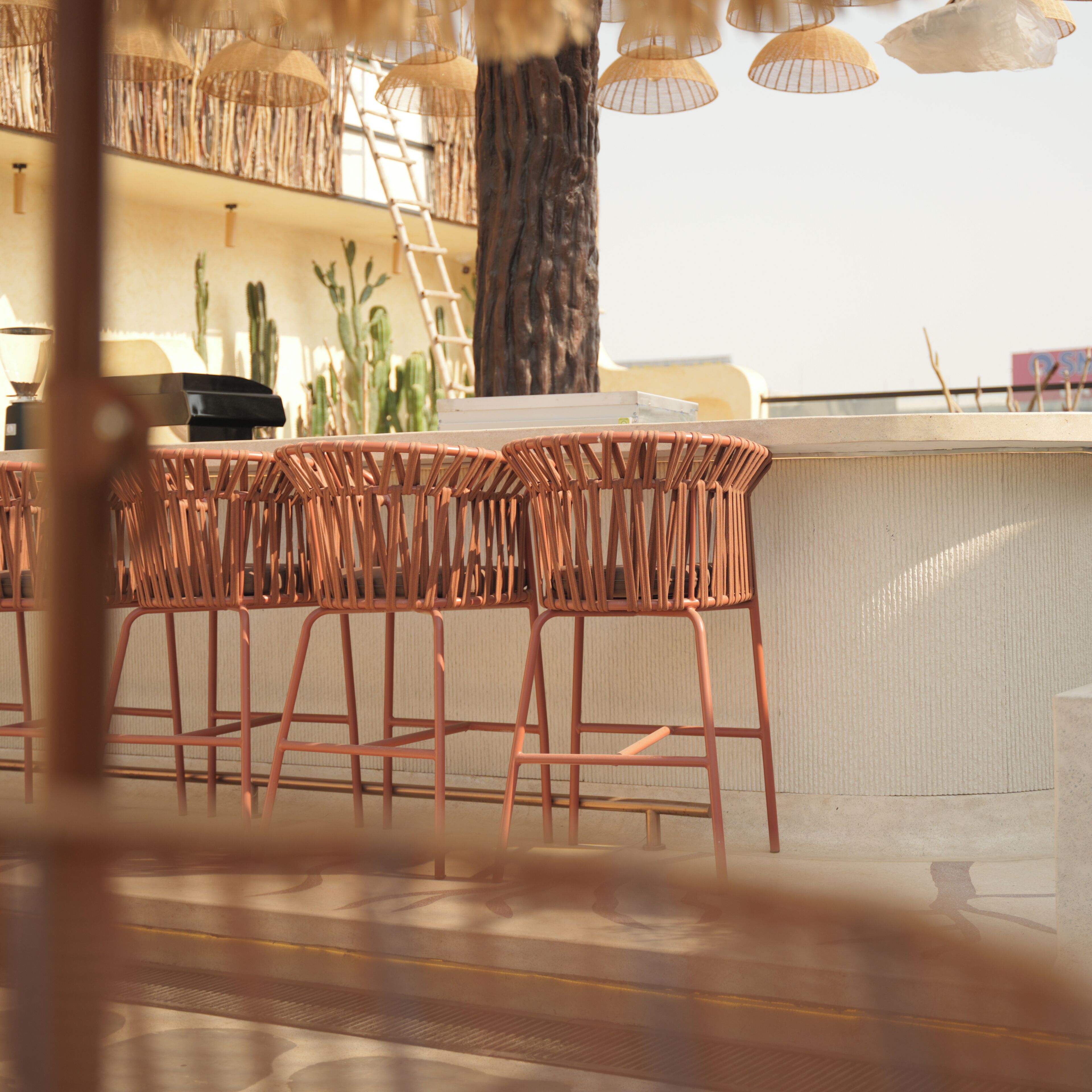 A bar area with wicker chairs and a high counter.
