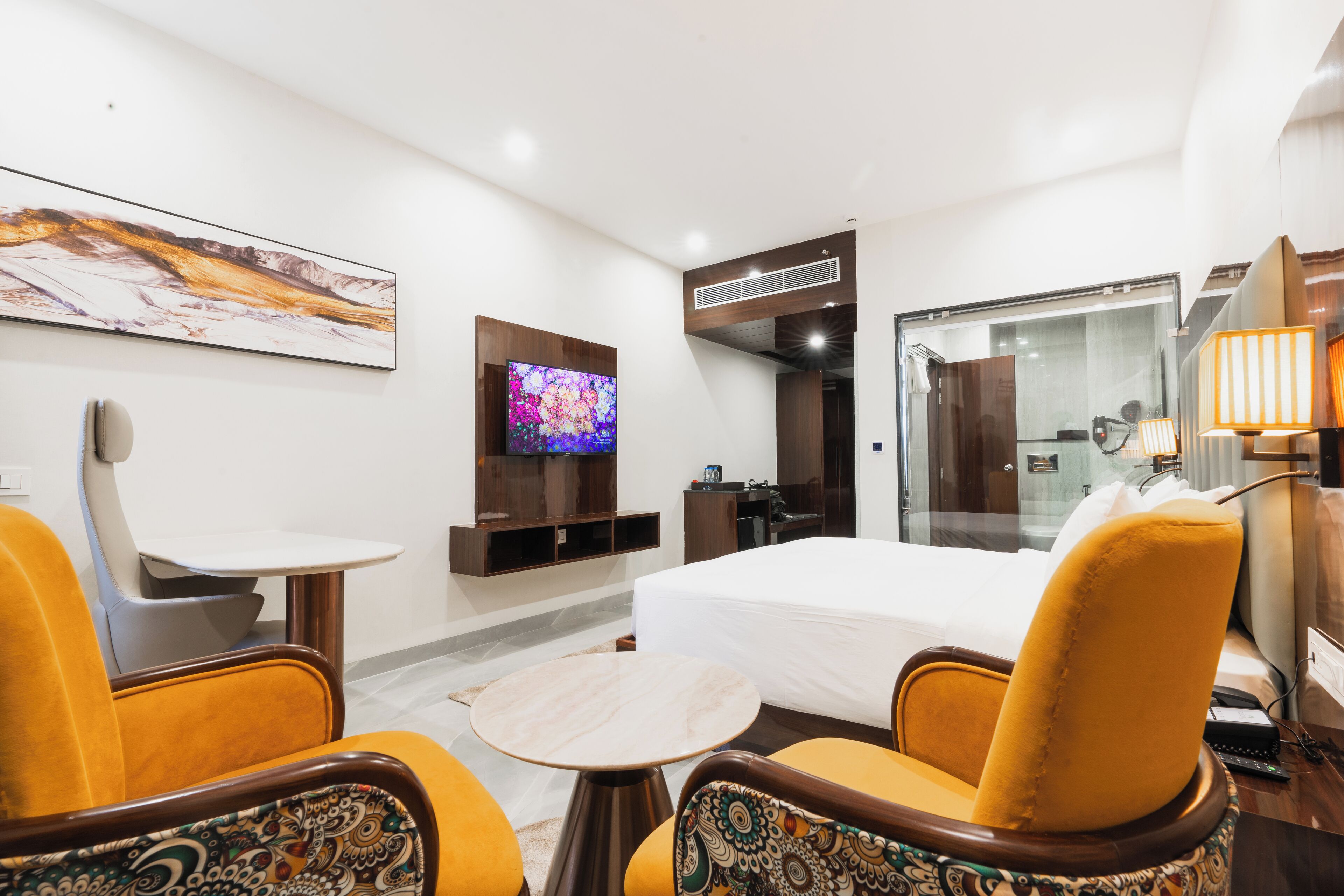 Una habitación de hotel con cama, televisor, escritorio y una silla.