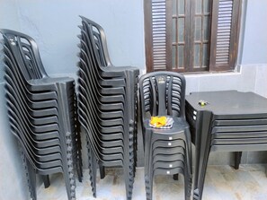 Ein Stapel Plastikstühle und ein Tisch im Freien.