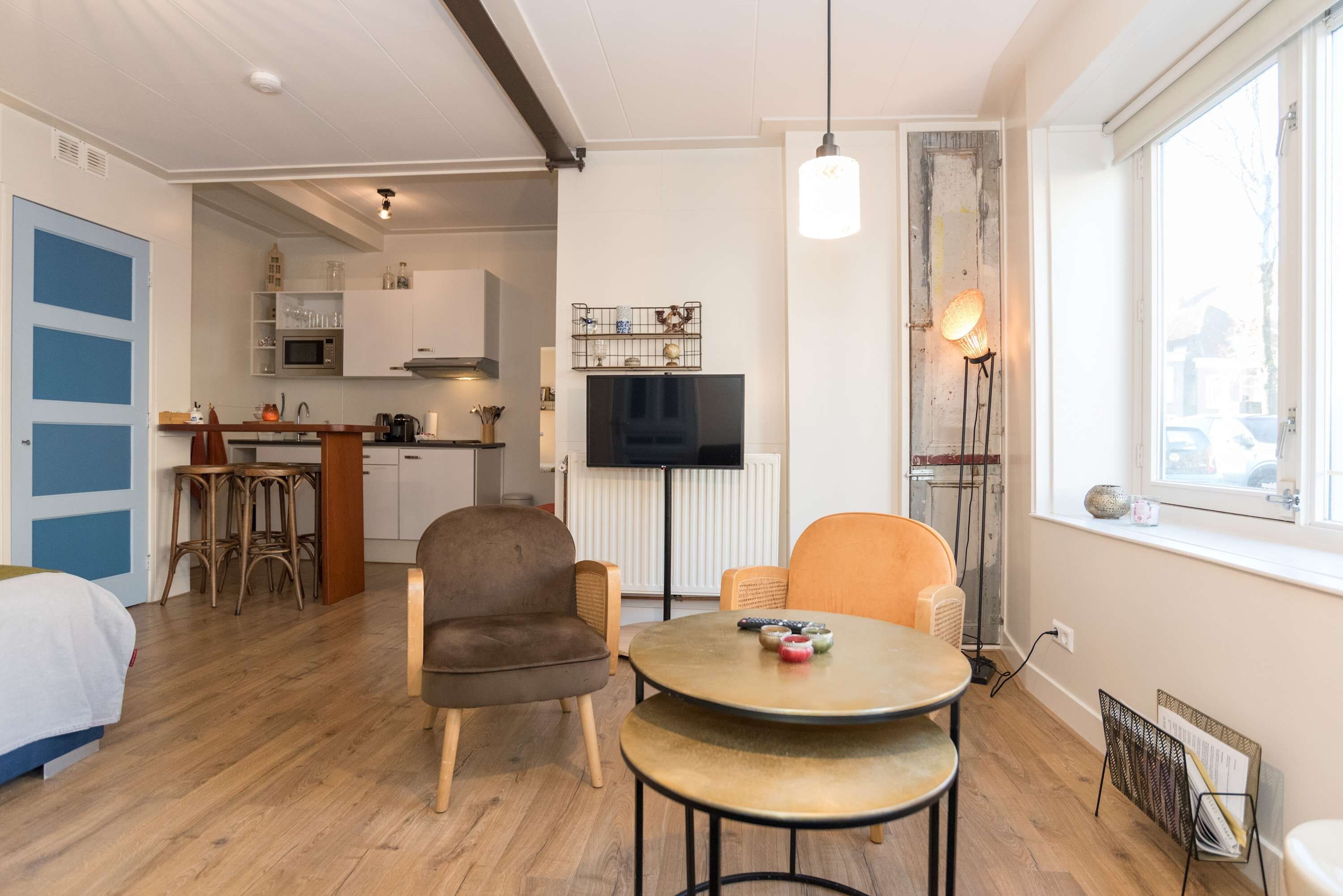 Un espace de vie compact comprenant une kitchenette, un coin repas et une chambre.