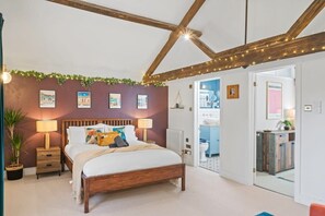 Une chambre à coucher avec un lit en bois, des tables de chevet, un radiateur et une porte donnant sur une salle de bain.
